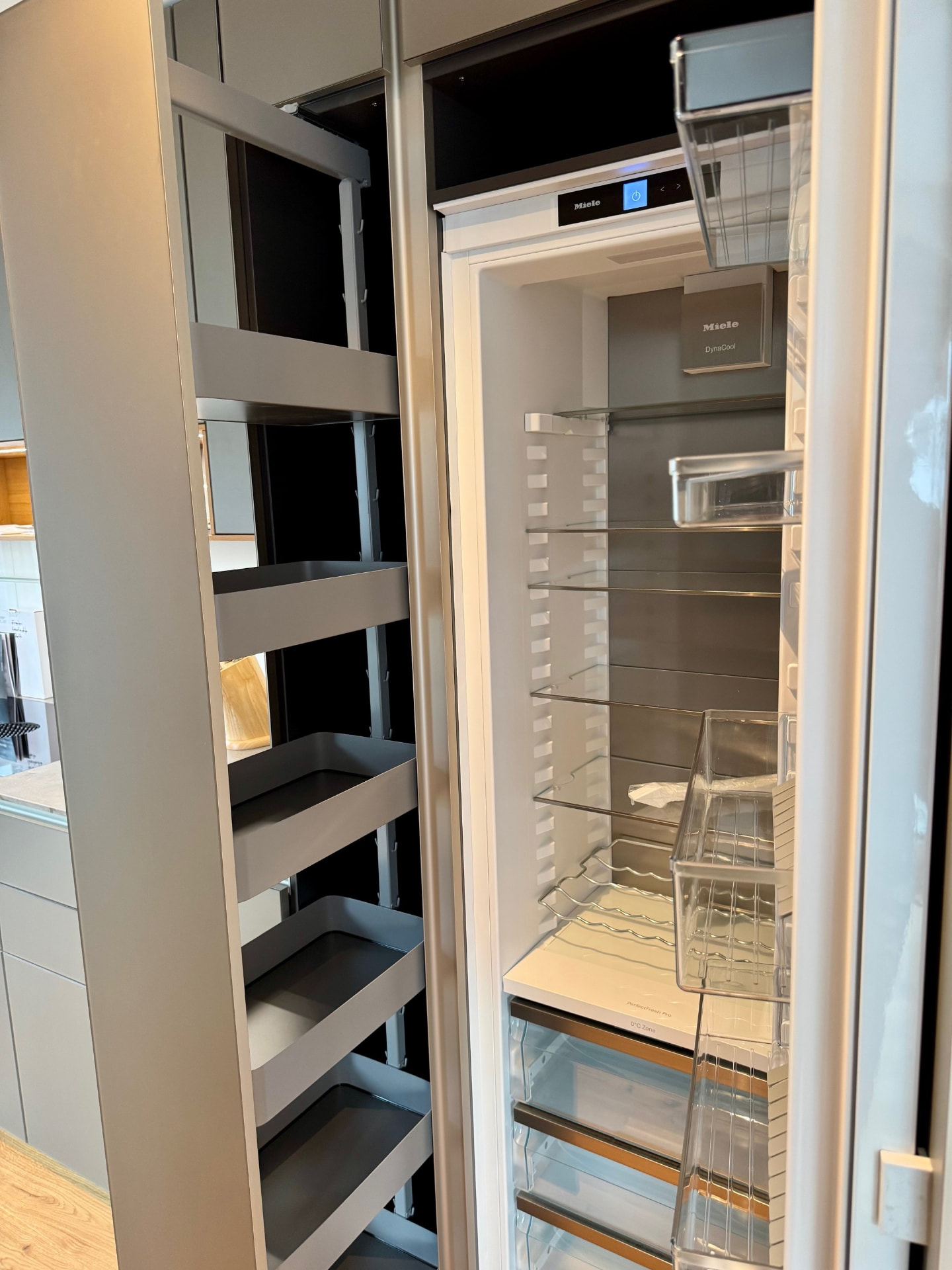 Apothekerschrank und integrierter Miele-Kühlschrank in der Küche.